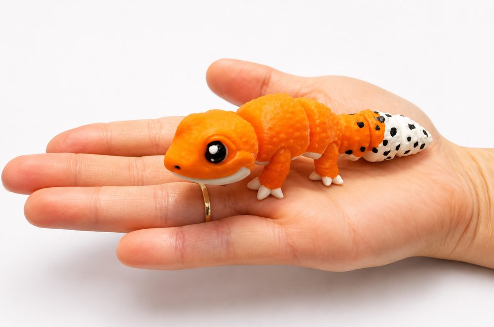 Full-colour 3D printed leopard gecko figure held in a hand for scale